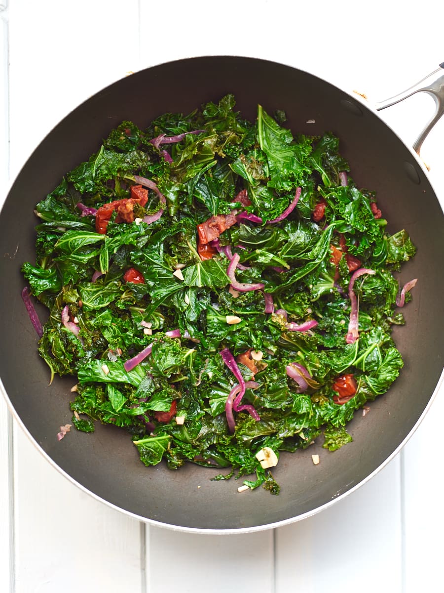 Sauteed kale with garlic and sundried tomatoes in pan