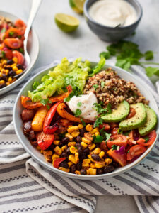 two mexican buddha bowls with a bowl of yoghurt and some limes