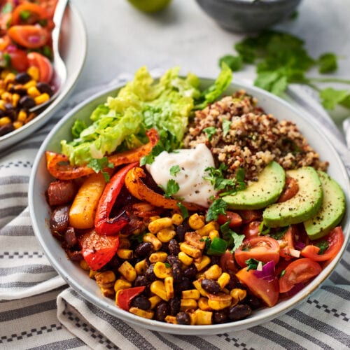 two mexican buddha bowls with a bowl of yoghurt and some limes