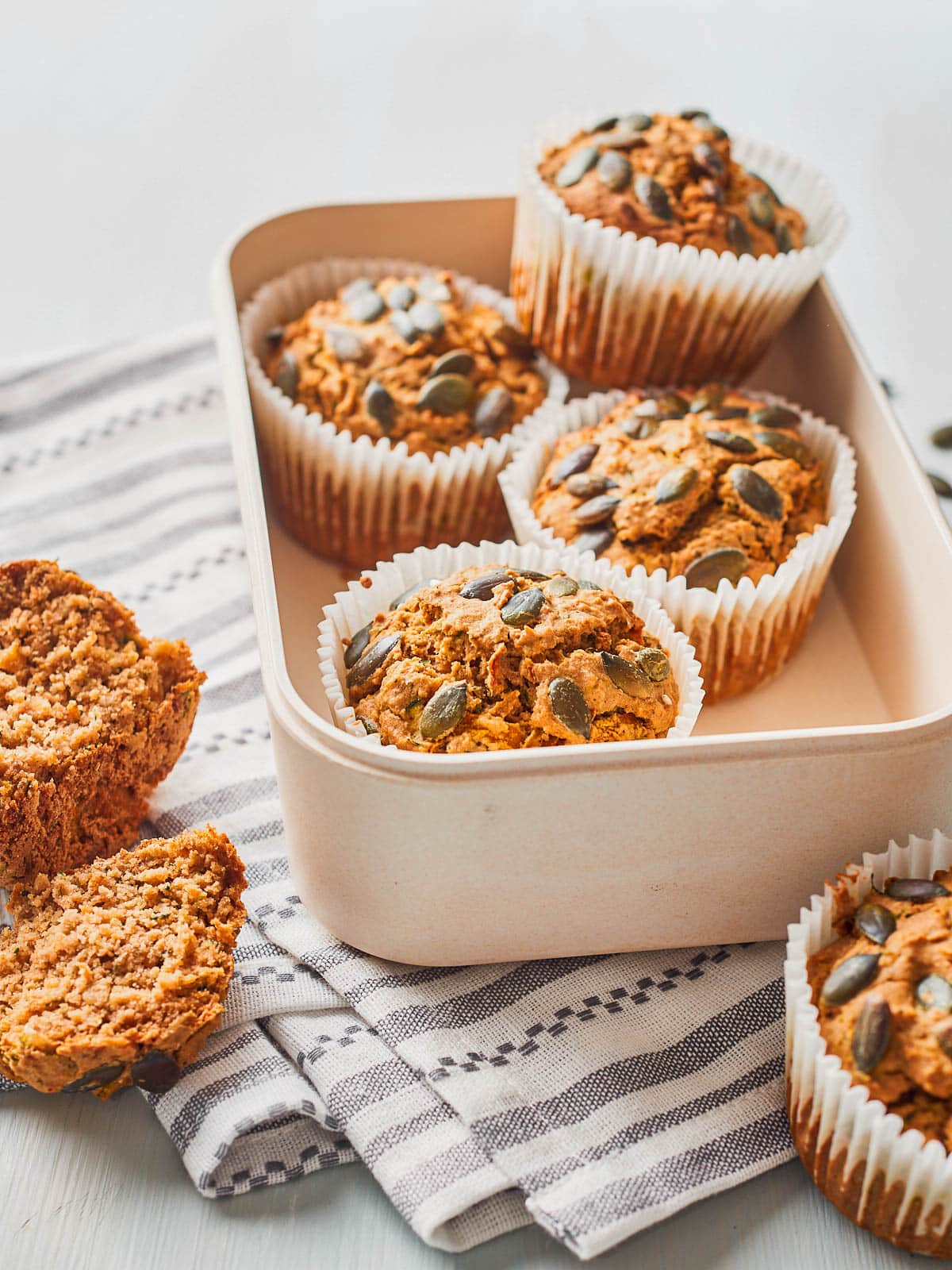 Savoury muffins piled up in a box with one torn open at the side