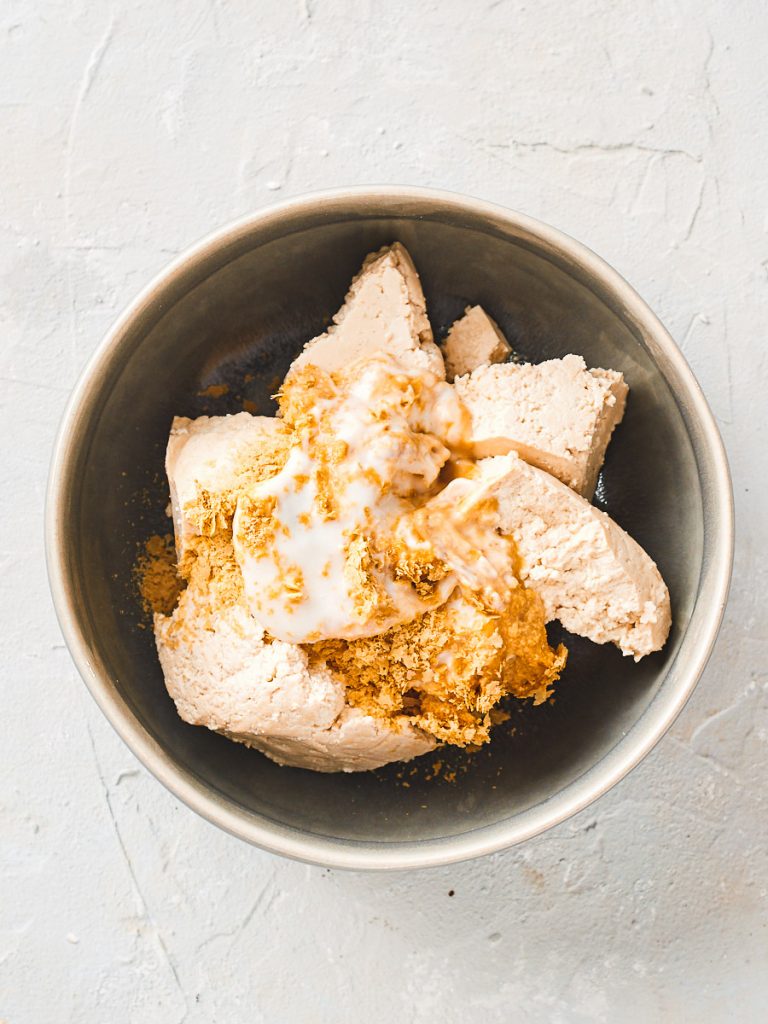 Tofu, yoghurt, nutritional yeast, vinegar, salt in a bowl