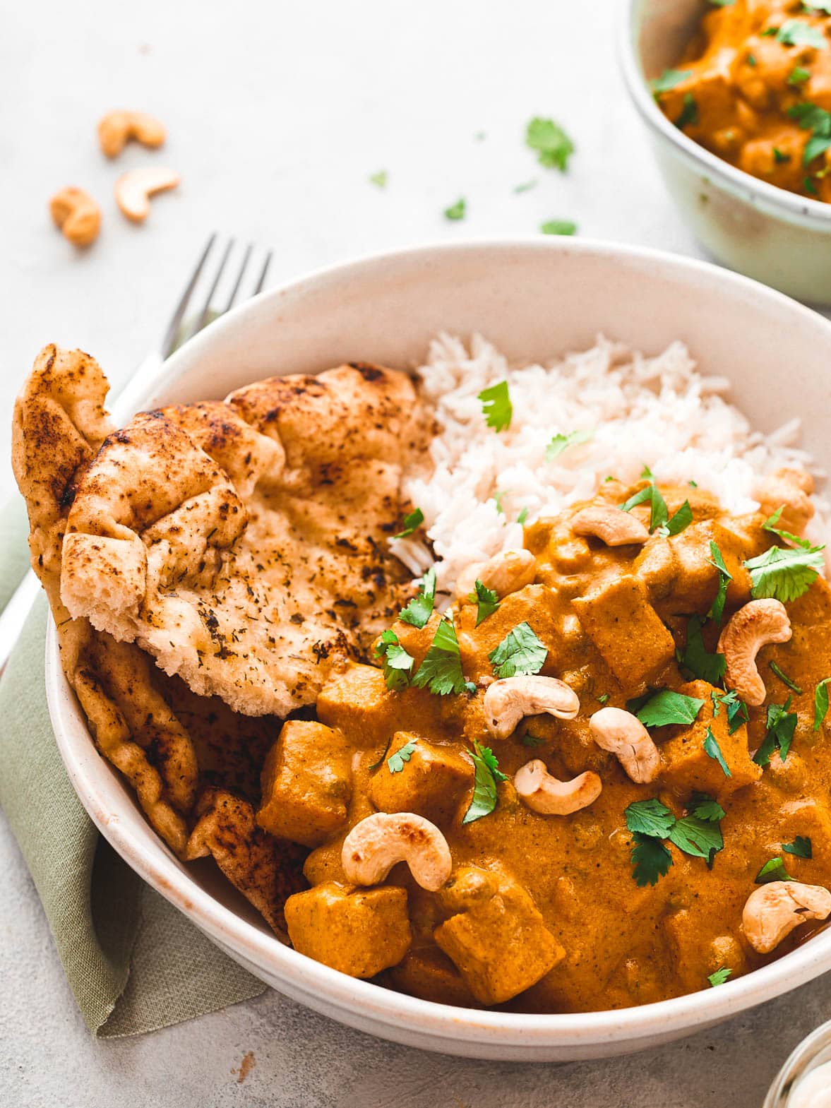 Vegan shahi korma in a bowl with rice and coriander