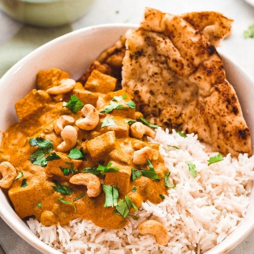 Vegan shahi korma in a bowl with rice and naan