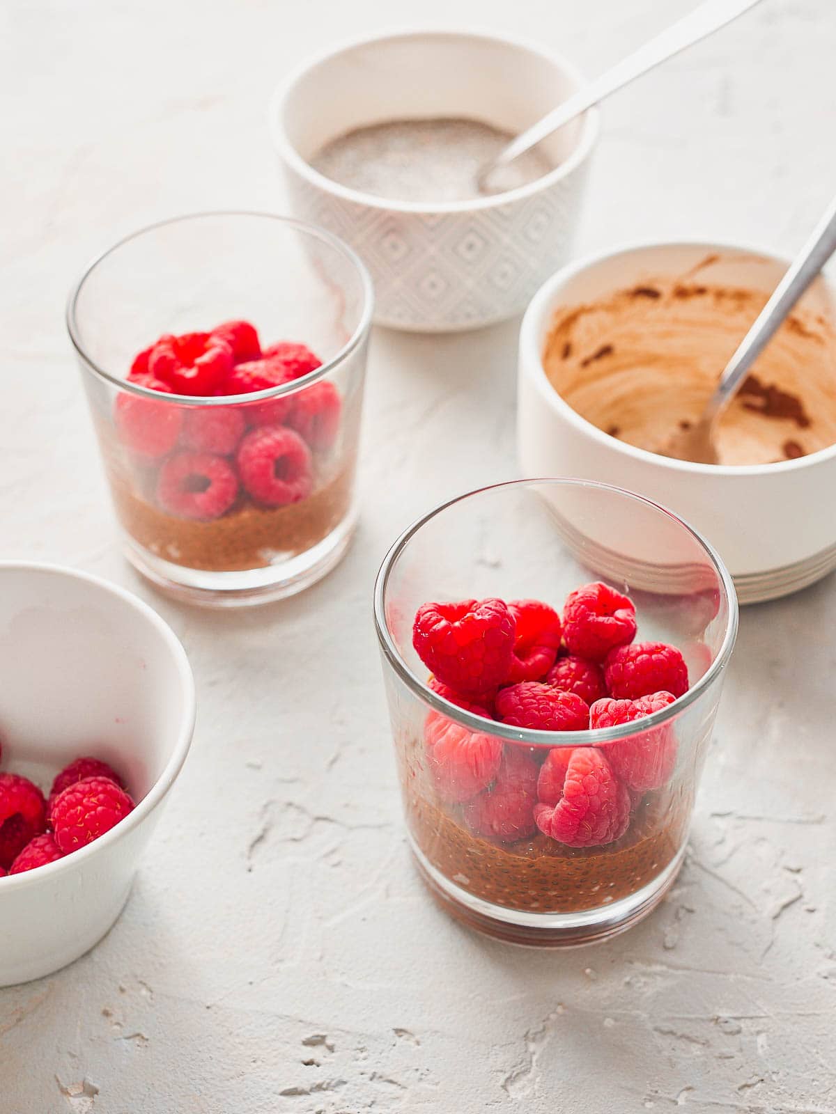 Adding raspberries on top of the chia pudding