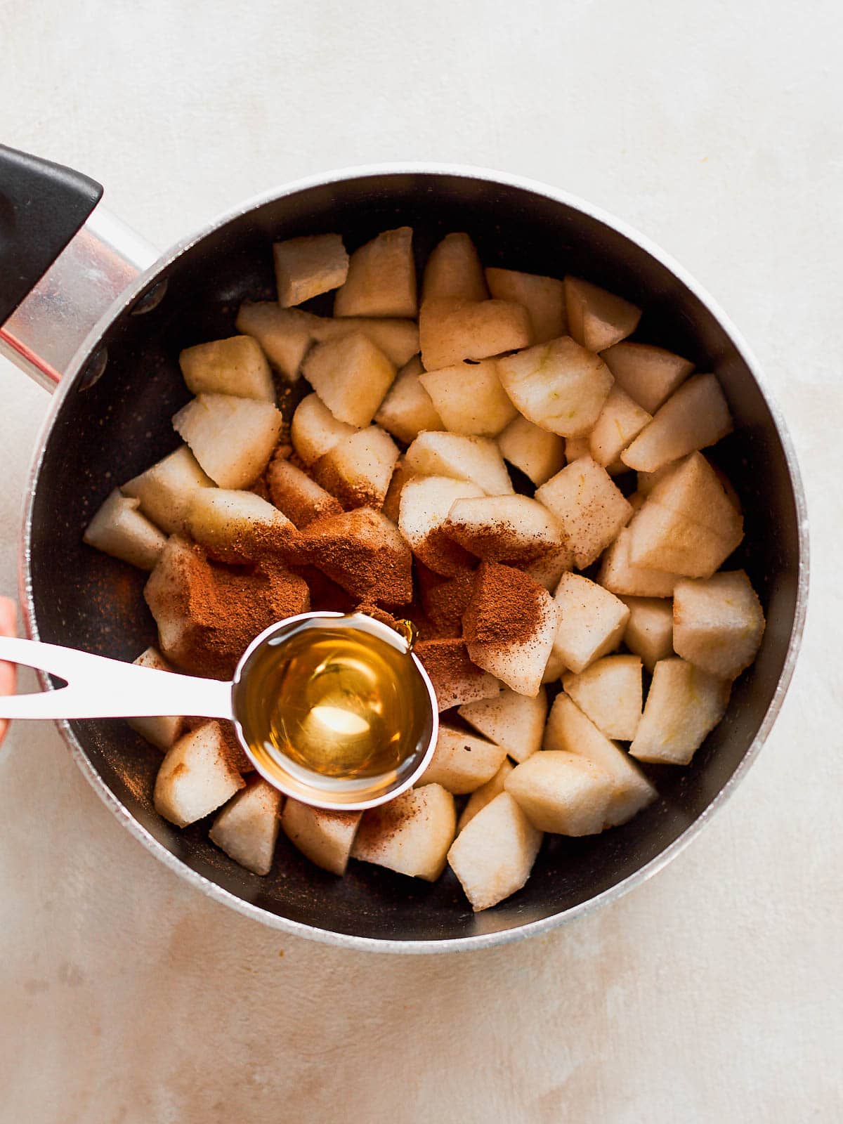 Adding syrup to pan with pears and spices