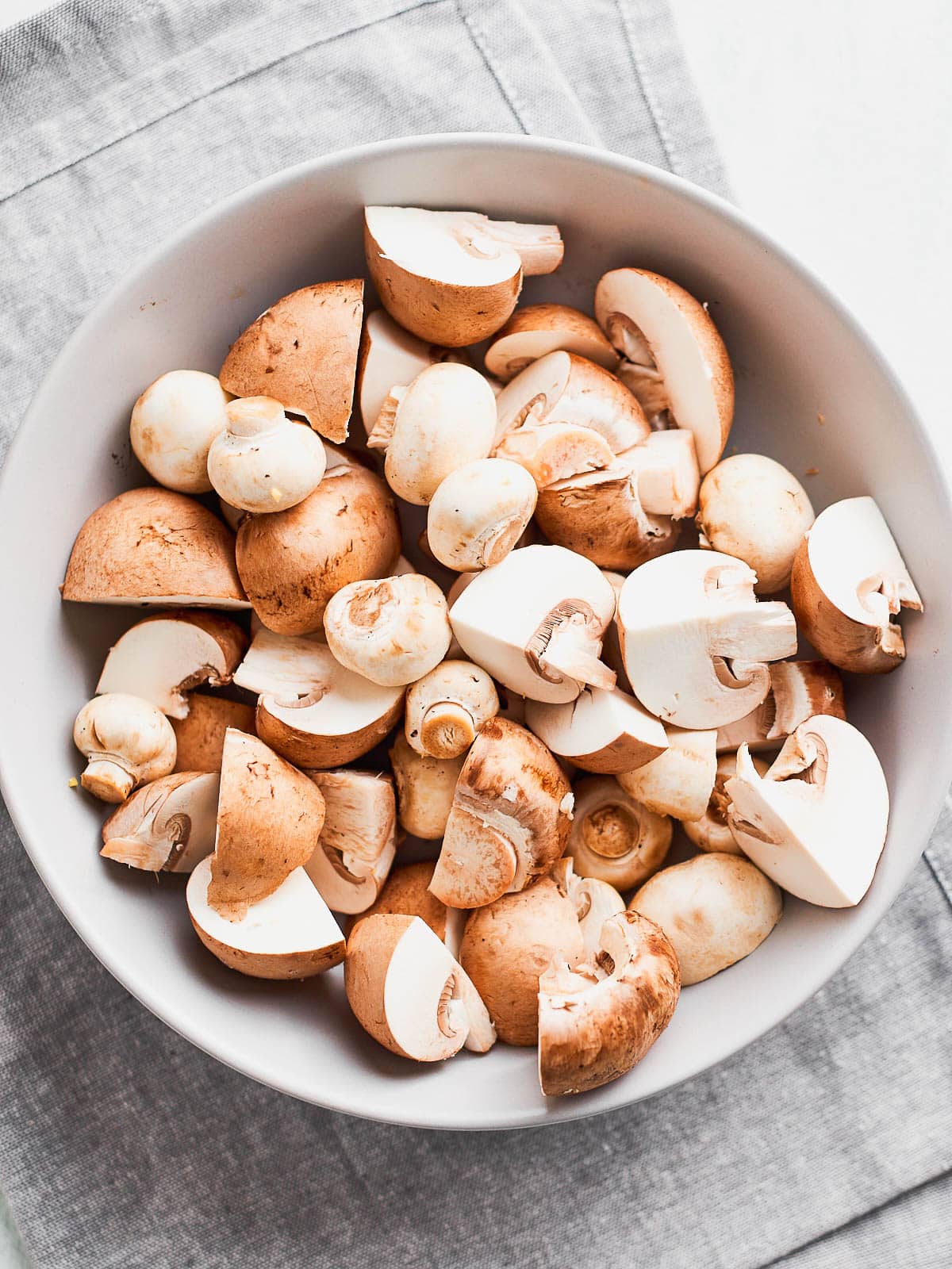 A bowl of mushrooms chopped into different sizes