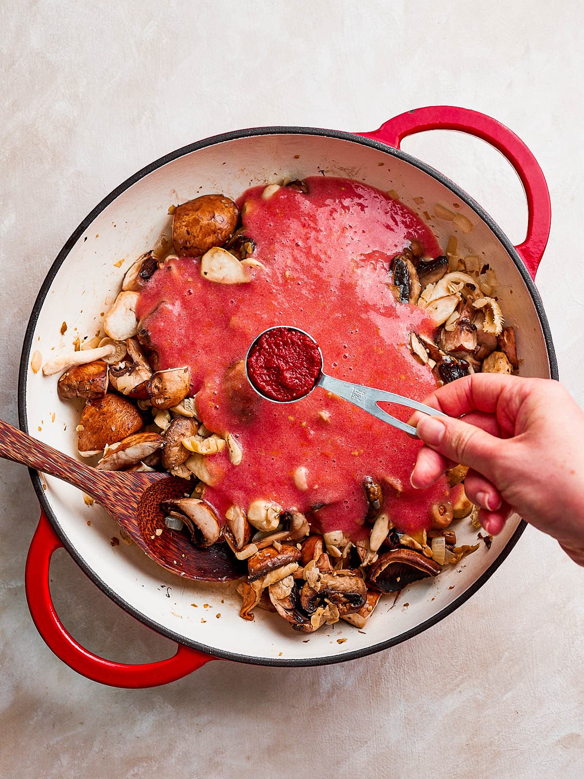 Adding the tomato paste to the pan