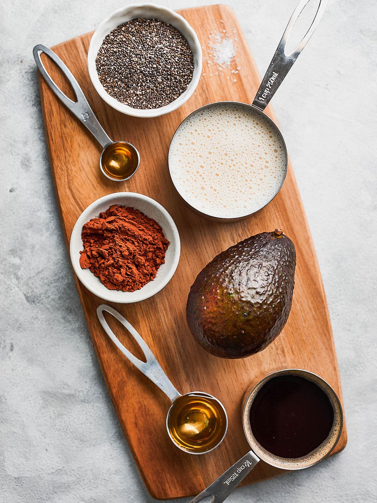 Ingredients for avocado chia pudding- avocado, coffee, maple syrup, cocoa powder, oat milk, chia seeds, vanilla.