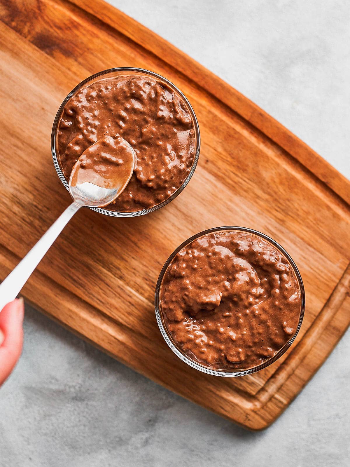 Smoothing out the top of the avocado chia pudding with a spoon