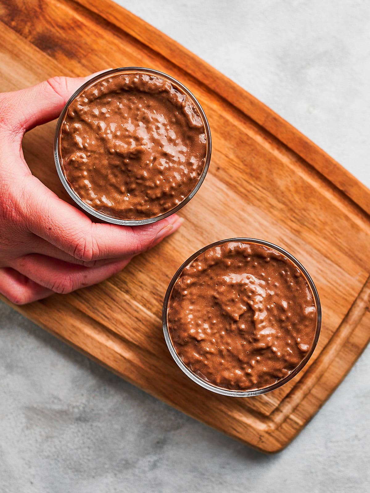 Shaking the avocado chia pudding jars to level the top